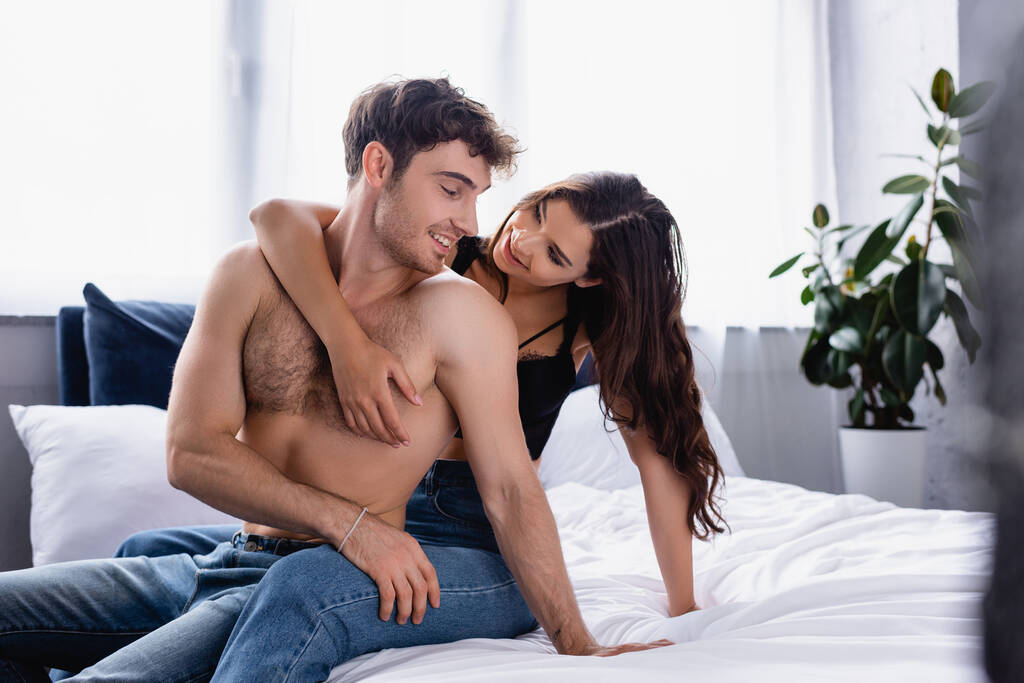selektywne skupienie kobiety patrzącej na mężczyznę bez koszulki siedzącego na łóżku - Zdjęcie, obraz