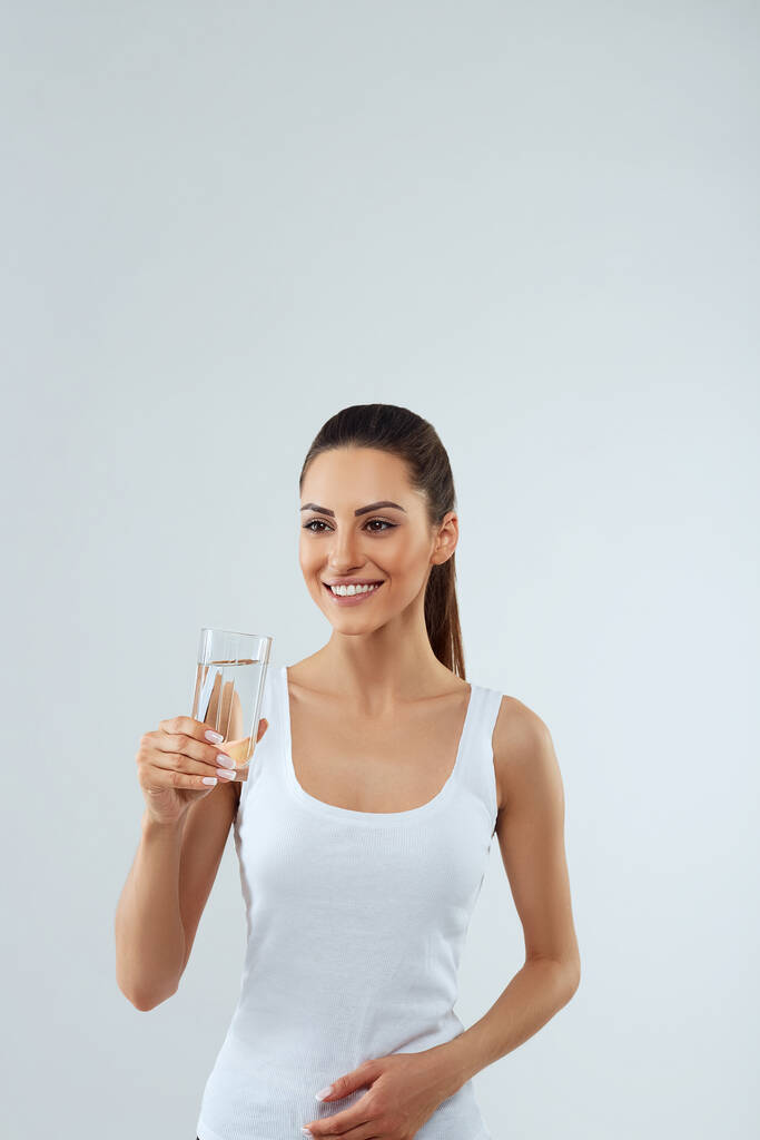 Portrait de belle femme avec beauté visage tenir verre d'eau. Bois de l'eau. Fille avec un verre d'eau. Concept de régime alimentaire - Photo, image