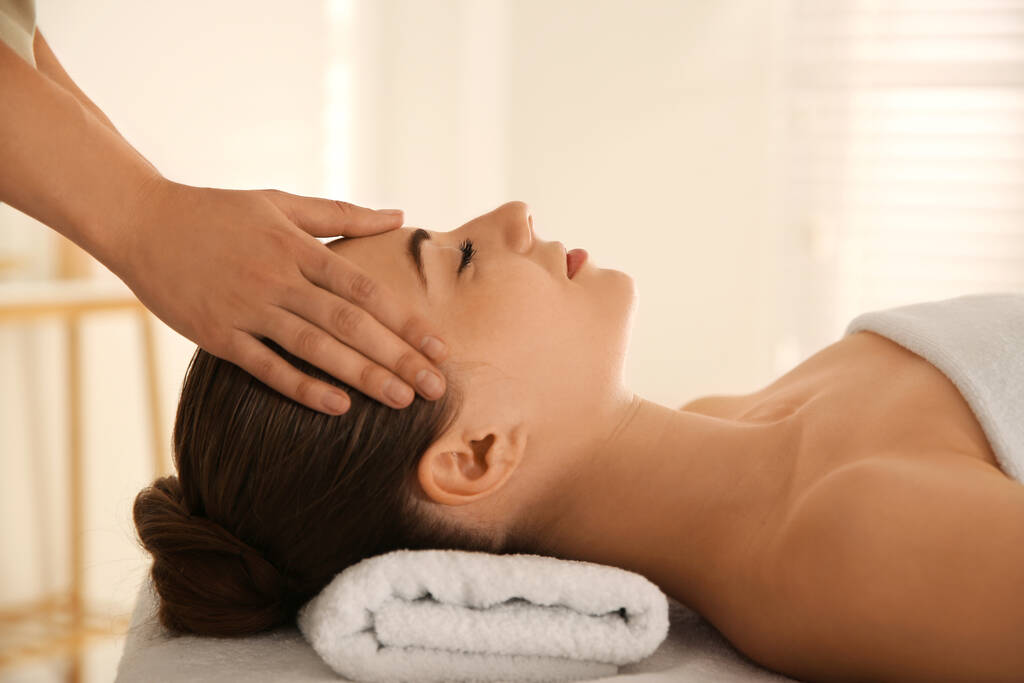 Mujer joven recibiendo masaje en la cabeza en el salón de spa - Foto, Imagen