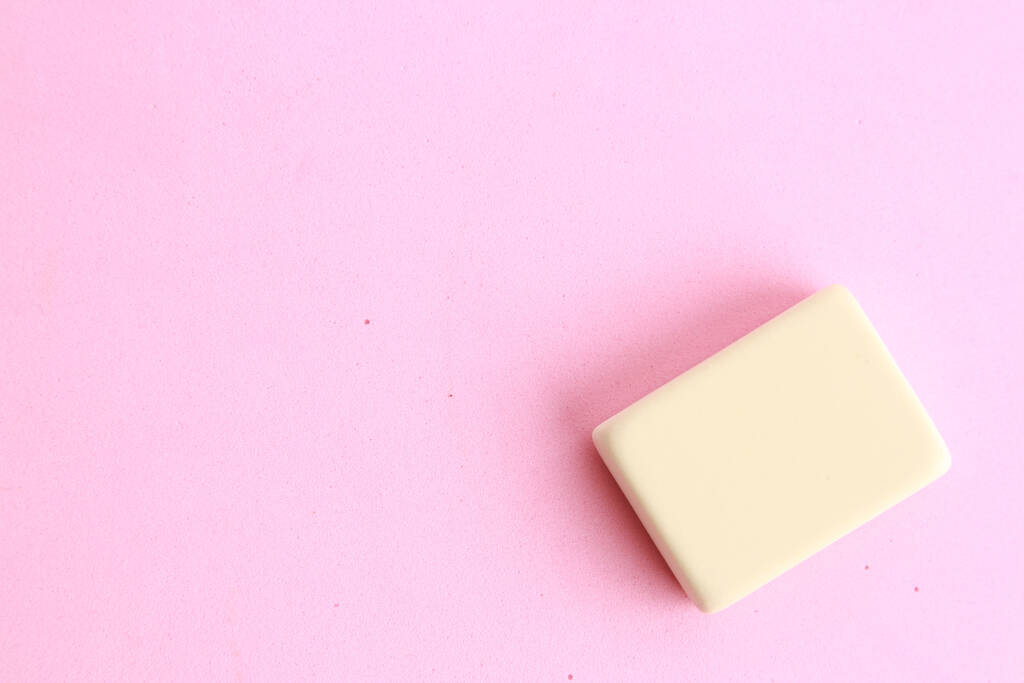 Een hoge hoek opname van een kleine gum geïsoleerd op een roze oppervlak - Foto, afbeelding