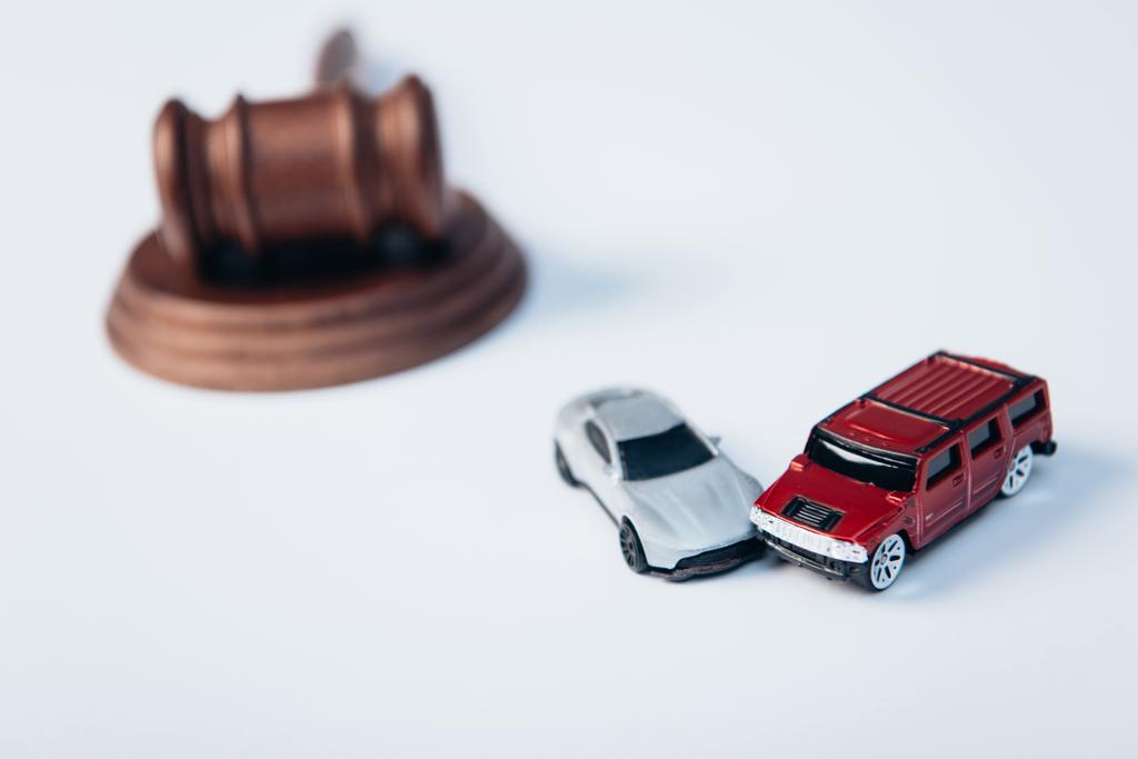 selective focus of toy cars near wooden gavel on white, insurance concept  - Photo, Image