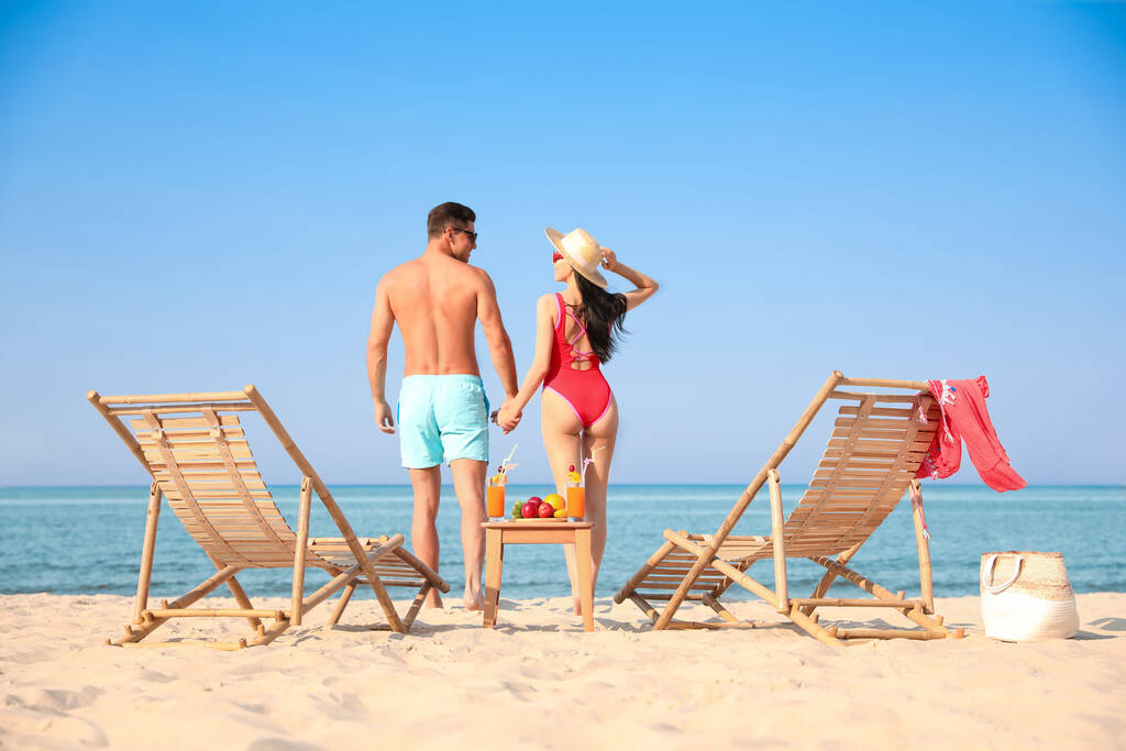 Couple reposant sur une plage ensoleillée à la station balnéaire - Photo, image