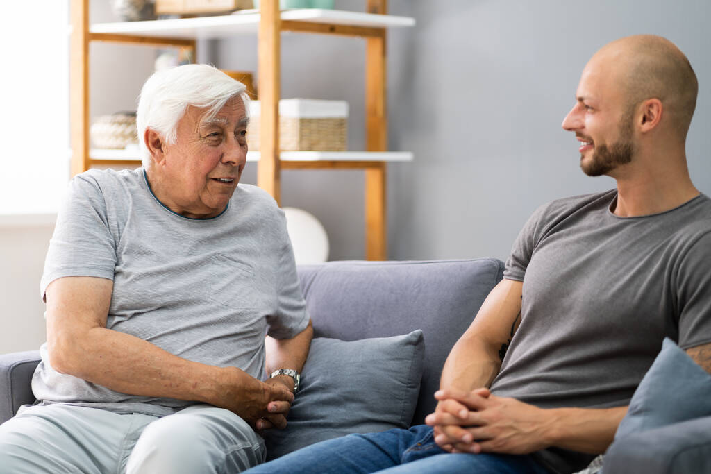 Großvater im Gespräch mit seinem Enkel im Wohnzimmer - Foto, Bild