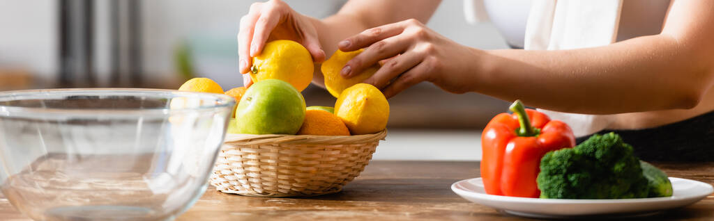 website header of woman touching lemons near vegetables on plate  - Photo, Image