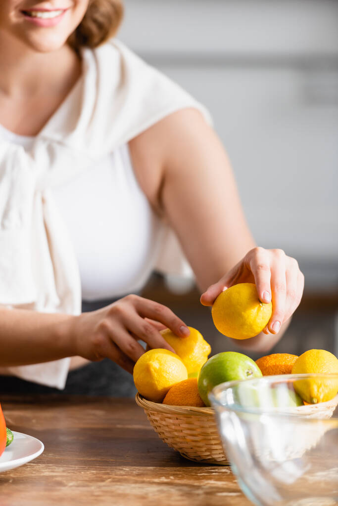 vista recortada de la mujer sosteniendo limones en las manos  - Foto, Imagen