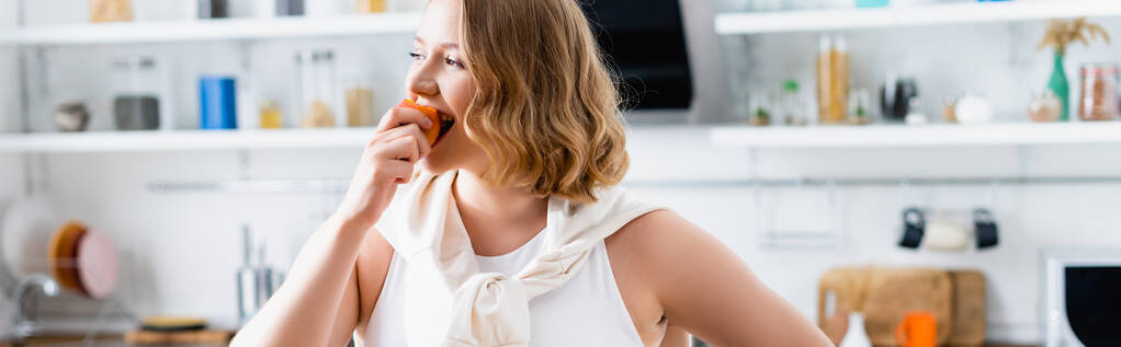 Frau isst in Küche frischen Pfirsich  - Foto, Bild