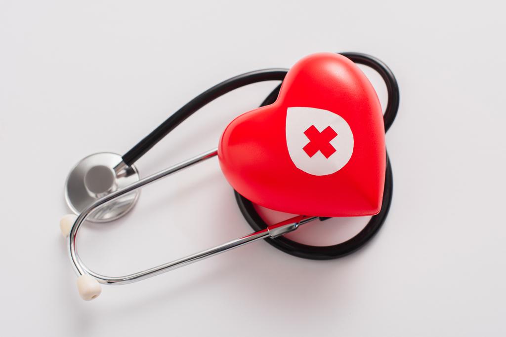 vista superior del corazón rojo y el estetoscopio en blanco, concepto de donación de sangre - Foto, Imagen