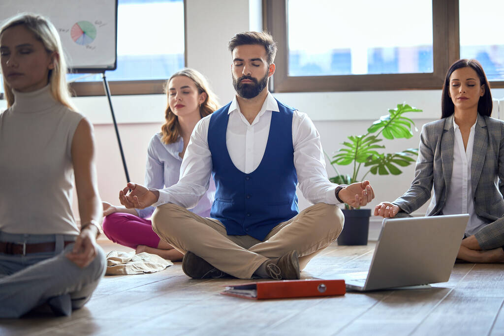 Junge Kollegen machen Yoga und konzentrieren sich im Büro - Foto, Bild