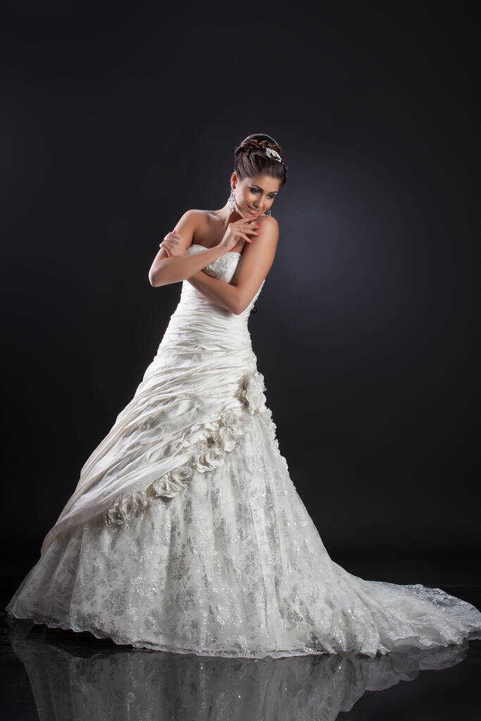 Young beautiful woman in a wedding dress on a studio background - Photo, Image