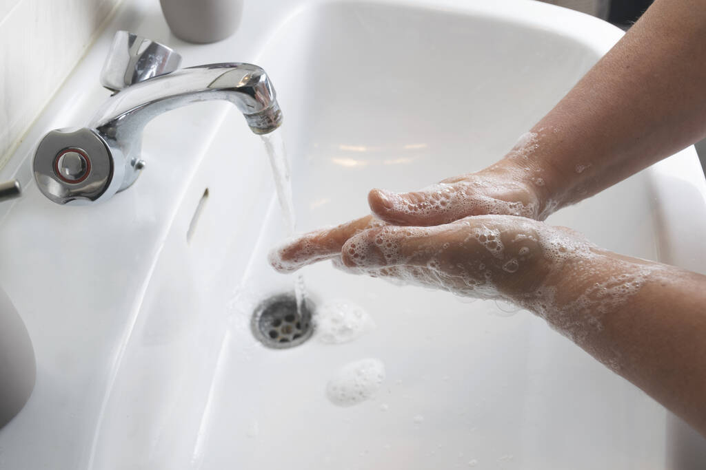 Korkea kulma laukaus mies pesee kätensä vaahtoava saippua valkoinen pesuallas COVID-19, coronavirus käsite - Valokuva, kuva