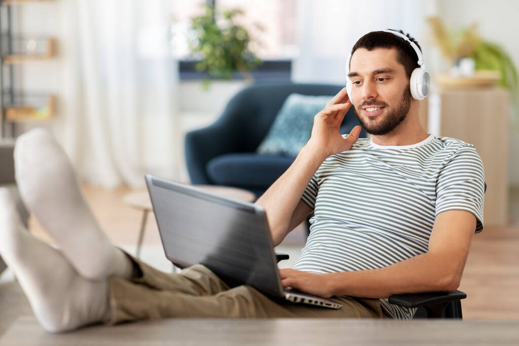 boldog ember laptop és fejhallgató otthon - Fotó, kép