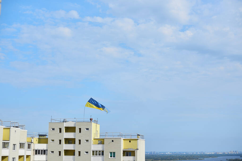 Drapeau national bleu et jaune de l'Ukraine agitant sur le haut immeuble d'appartements pour la fête de l'indépendance. Jour du drapeau. Symboles nationaux du pays. - Photo, image