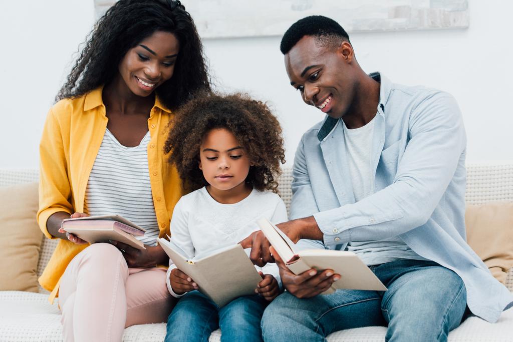 Afrikkalainen amerikkalainen vanhemmat ja lapsi katselee kirjaa  - Valokuva, kuva