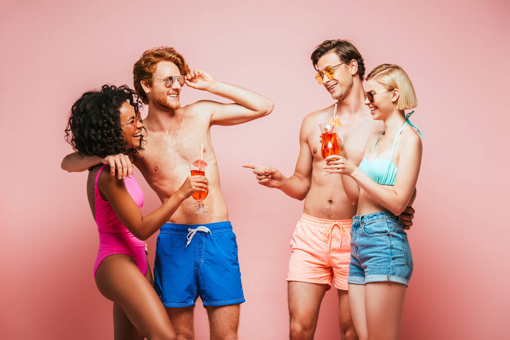 без сорочки чоловік вказує пальцем біля мультикультурних друзів тримає коктейлі ізольовані на рожевому
 - Фото, зображення