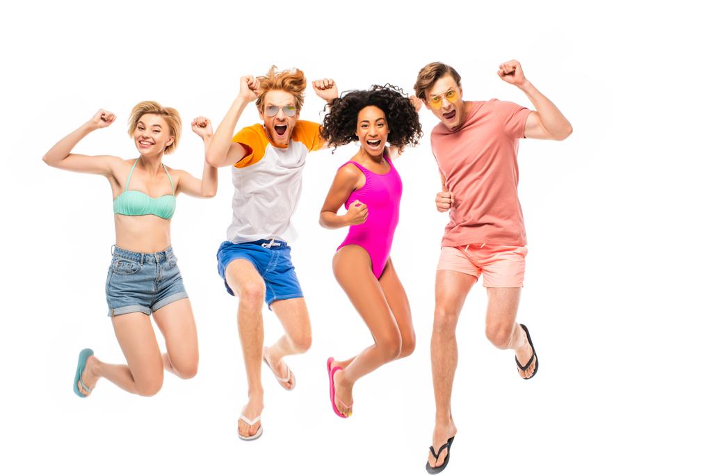 Мультиэтнические друзья в солнцезащитных очках и купальниках, показывающие да жест во время прыжка изолированы на белом - Фото, изображение
