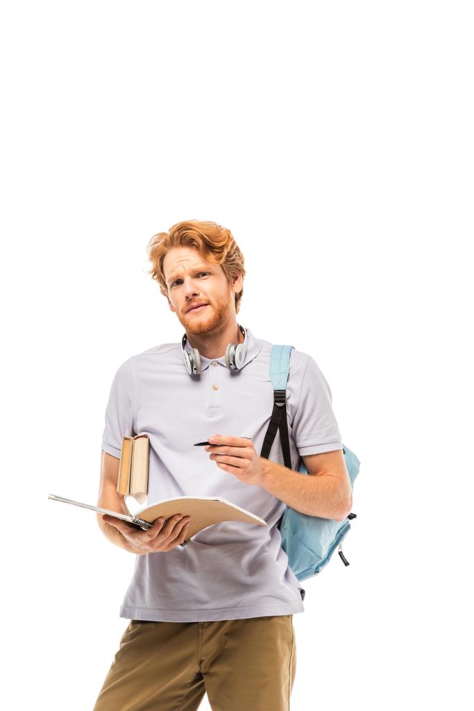 Student s batohem drží notebook a pero při pohledu na fotoaparát izolované na bílém - Fotografie, Obrázek