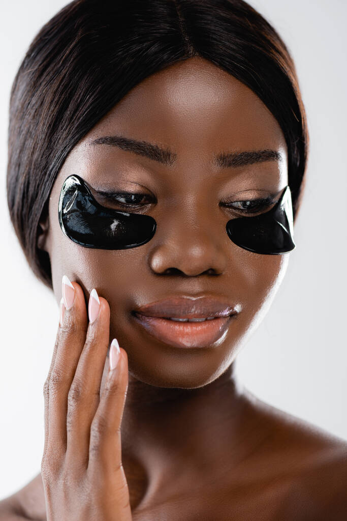 portrait of african american naked woman with hydrogel eye patches on face isolated on white - Photo, Image