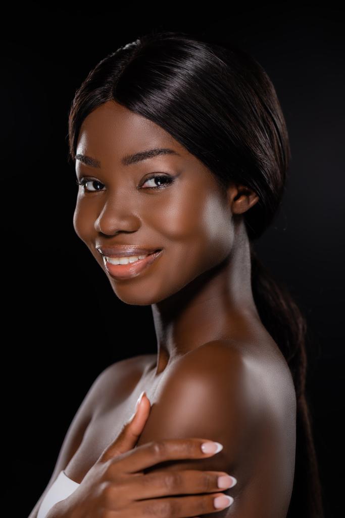портрет африканской американки, смотрящей в камеру, изолированную на черном - Фото, изображение