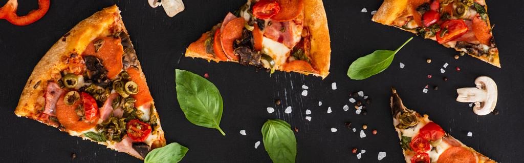 top view of delicious Italian pizza slices with vegetables and salami on black background, panoramic shot - Photo, Image