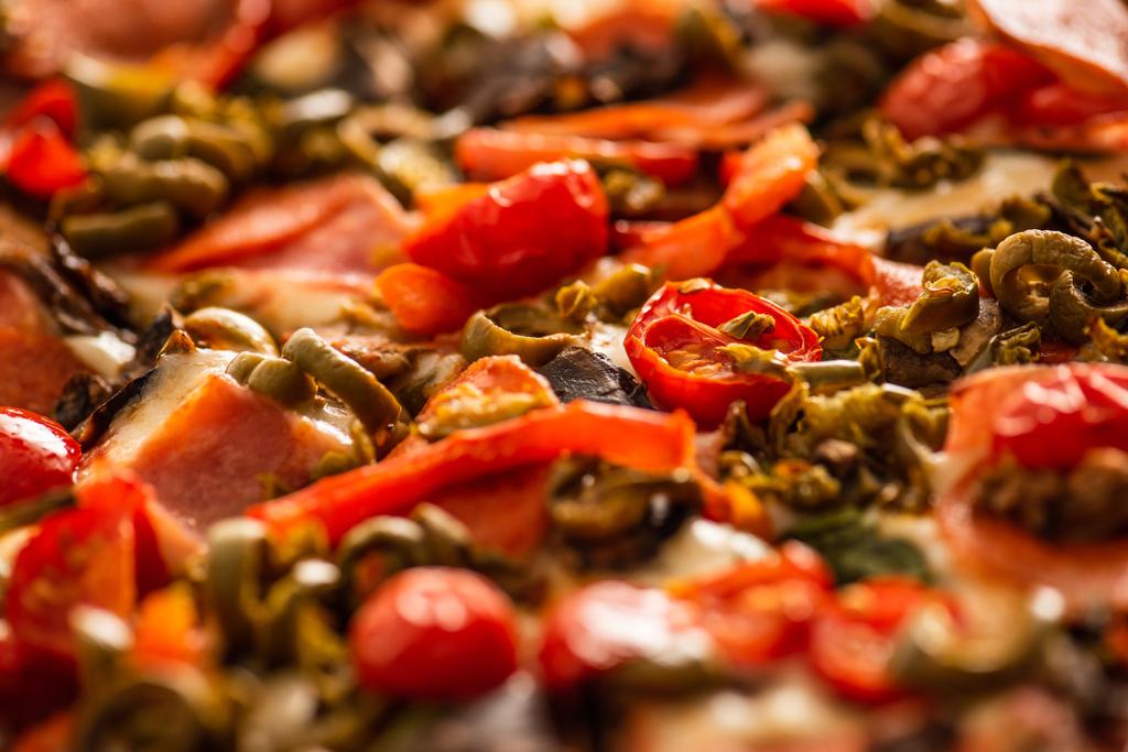 野菜とサラミのおいしいイタリアのピザのビューを閉じます - 写真・画像
