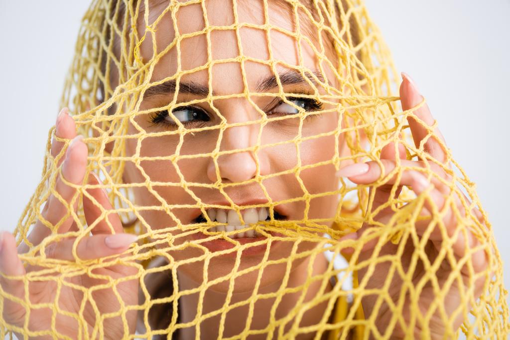 nő harapás sárga string táska fehér háttér - Fotó, kép