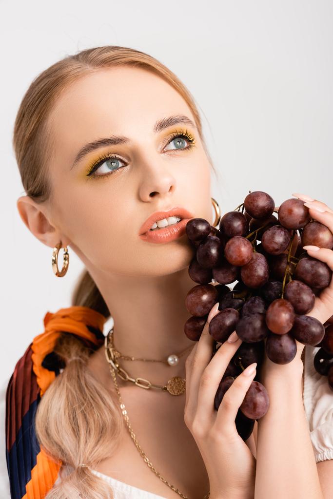 rusztikus szőke nő pózol szőlő és nézte félre elszigetelt fehér - Fotó, kép
