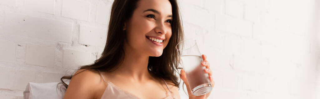 panoramiczne ujęcie młodej kobiety trzymającej szklankę z wodą  - Zdjęcie, obraz