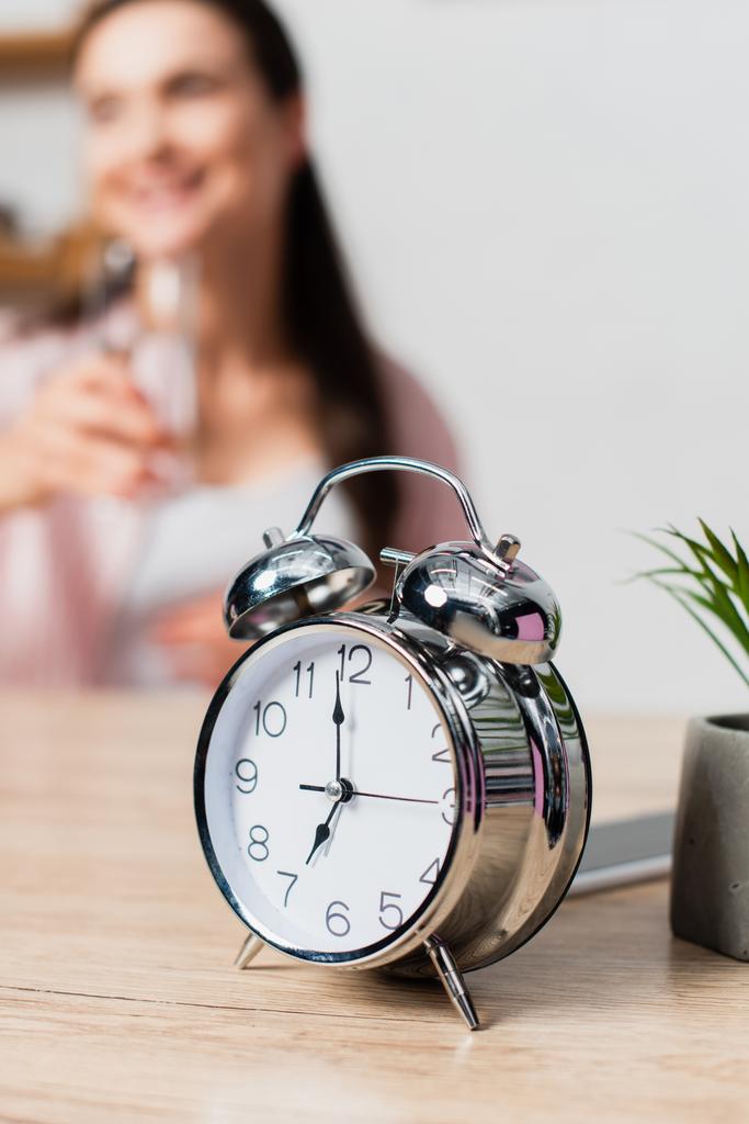 selective focus of vintage alarm clock near brunette woman  - Photo, Image