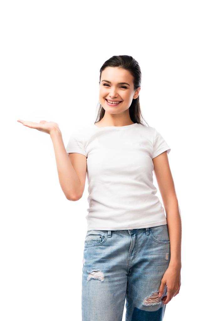 jovem mulher em t-shirt branca e jeans apontando com a mão isolada em branco  - Foto, Imagem