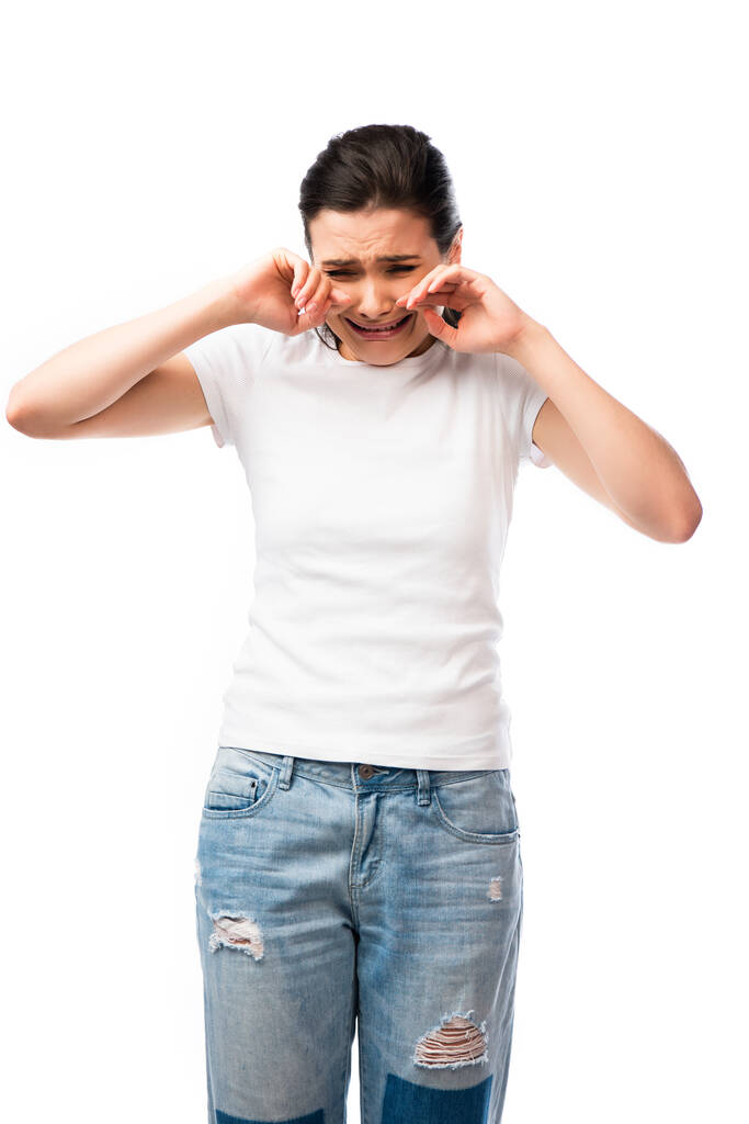 μελαχρινή γυναίκα σε λευκό t-shirt κλαίει απομονωμένη σε λευκό  - Φωτογραφία, εικόνα
