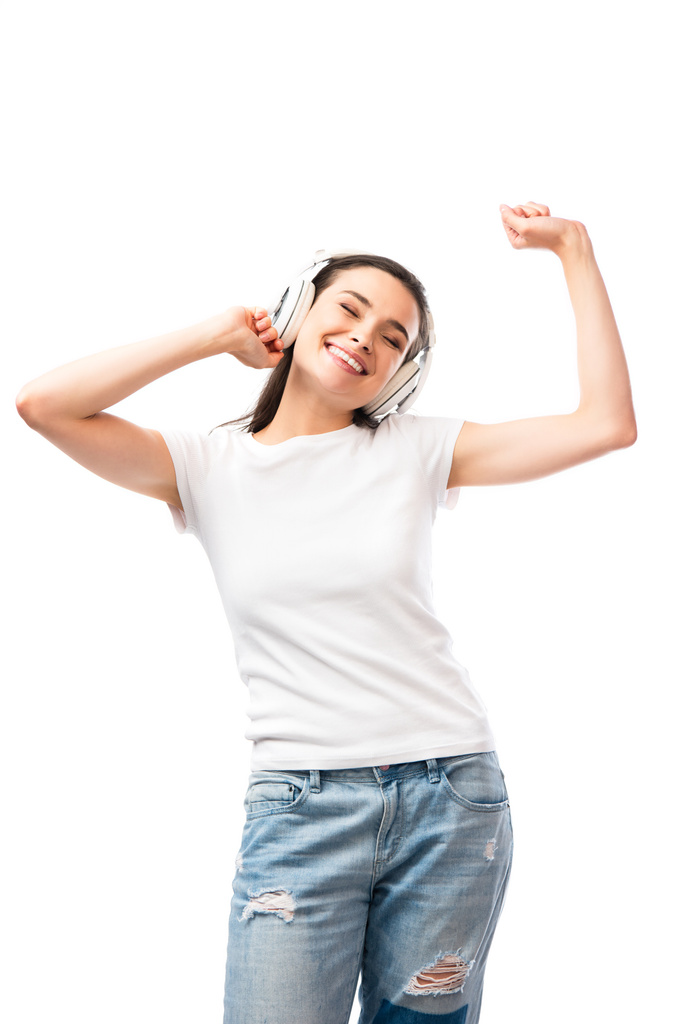 νεαρή γυναίκα με κλειστά μάτια σε λευκό t-shirt και ασύρματα ακουστικά που απομονώνονται σε λευκό  - Φωτογραφία, εικόνα