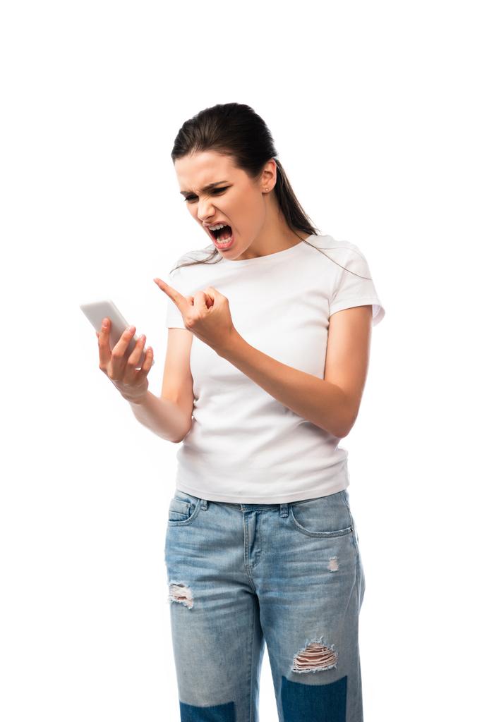 mulher descontente gritando e mostrando o dedo médio enquanto segurando smartphone isolado no branco  - Foto, Imagem