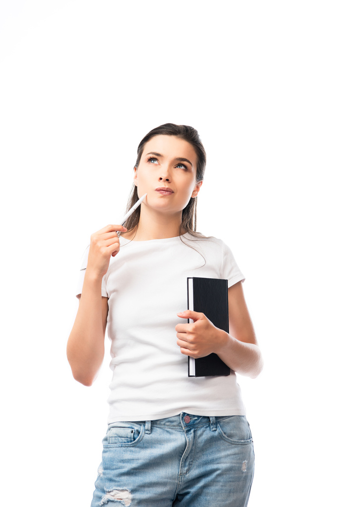 nachdenkliche Frau im weißen T-Shirt mit Notizbuch und Stift auf weißem Hintergrund  - Foto, Bild