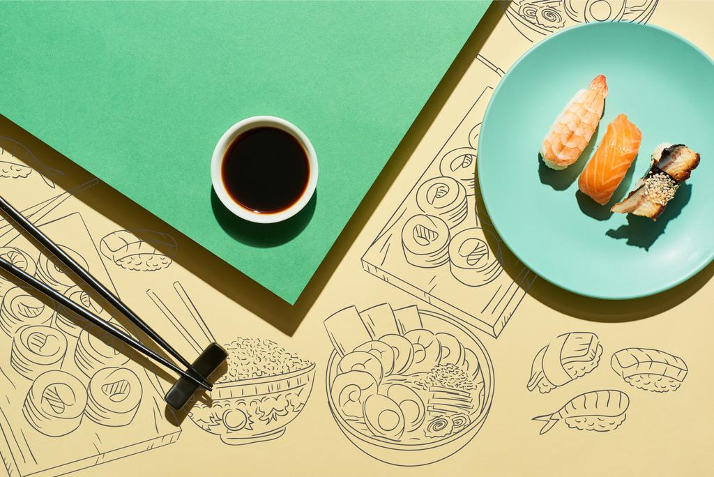 верхний вид нигири рядом с соевым соусом, палочками и японской пищевой иллюстрацией на зеленой и желтой поверхности - Фото, изображение