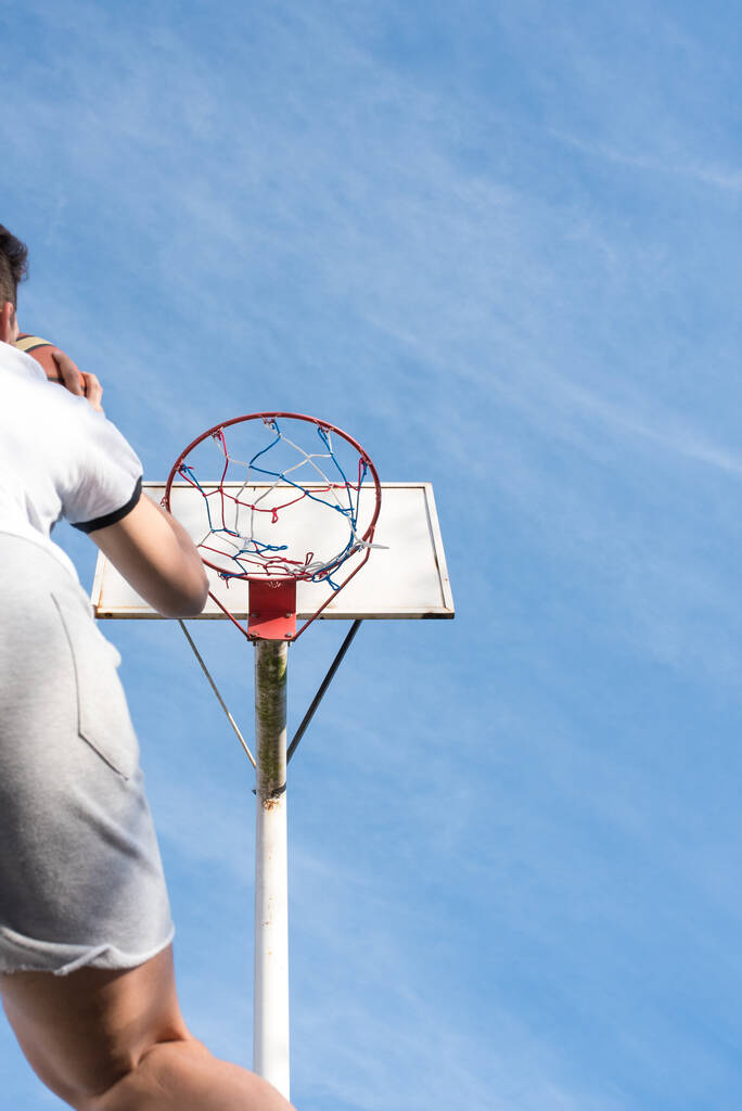Un tiro vertical de bajo ángulo de un hombre jugando baloncesto - Foto, imagen