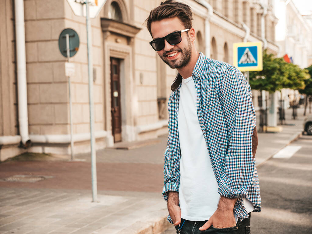 Porträt eines hübschen lächelnden stilvollen Hipster-Lambersexual-Model.Mann im Hemd. Modemännchen posiert mit Sonnenbrille auf der Straße - Foto, Bild