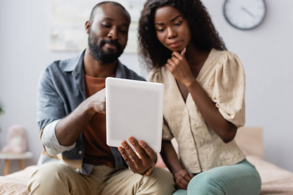 アフリカ系アメリカ人男性が思慮深い妻の近くにデジタルタブレットを持ち - 写真・画像