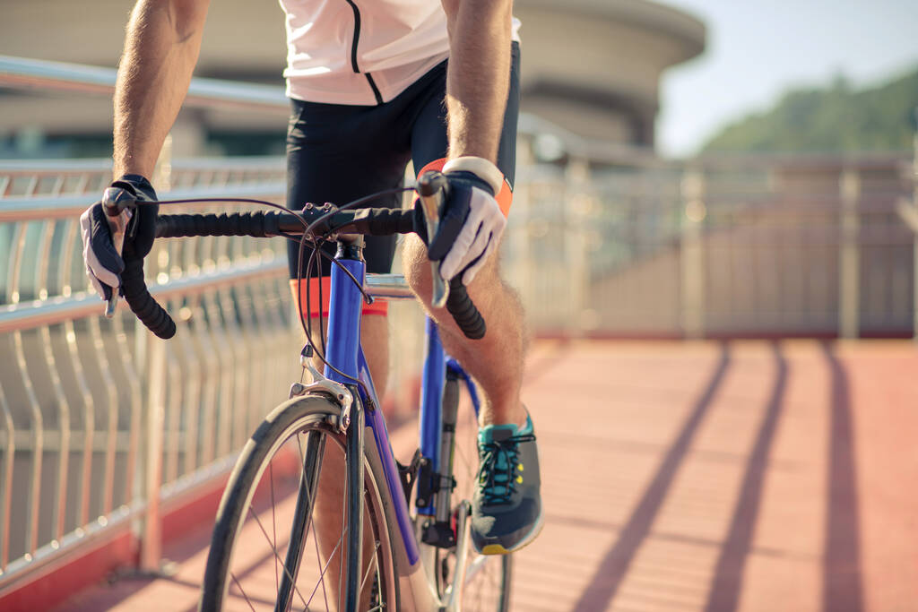 Pyöräilijän jalat polkupyörän polkeminen sillalla - Valokuva, kuva