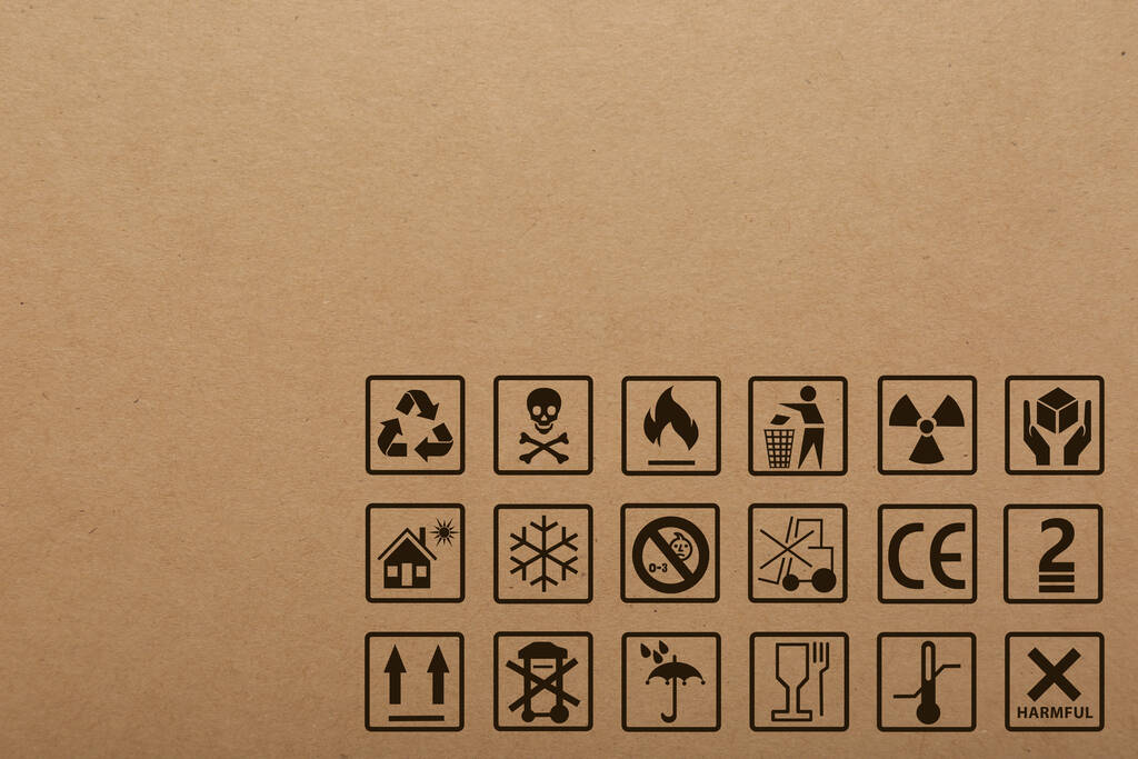 Pudełko tekturowe z symbolami opakowań jako tłem, zbliżenie - Zdjęcie, obraz
