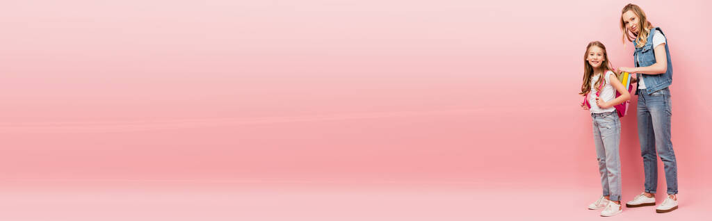 バックパックを背負った母親の長さをピンクに塗りパノラマ写真を撮る - 写真・画像