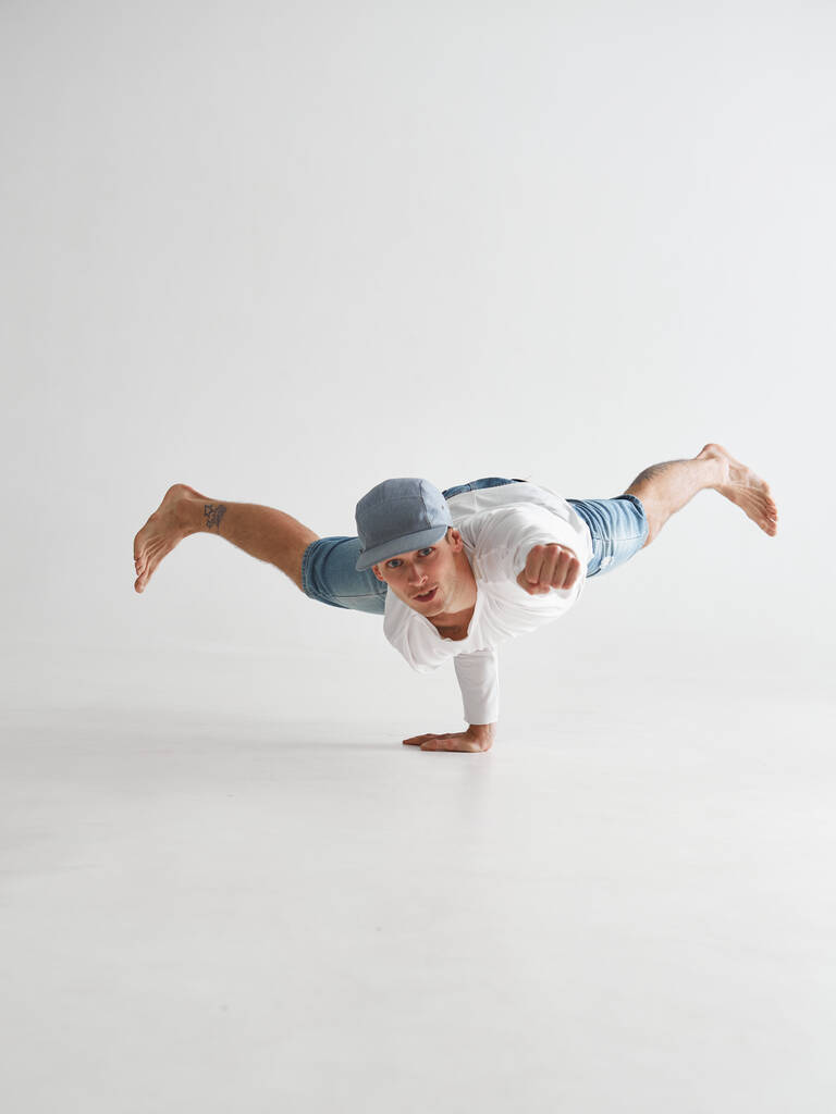 Giovane breakdancer si erge su un braccio ballare hip-hop isolato su sfondo bianco. Break poster della scuola di danza - Foto, immagini
