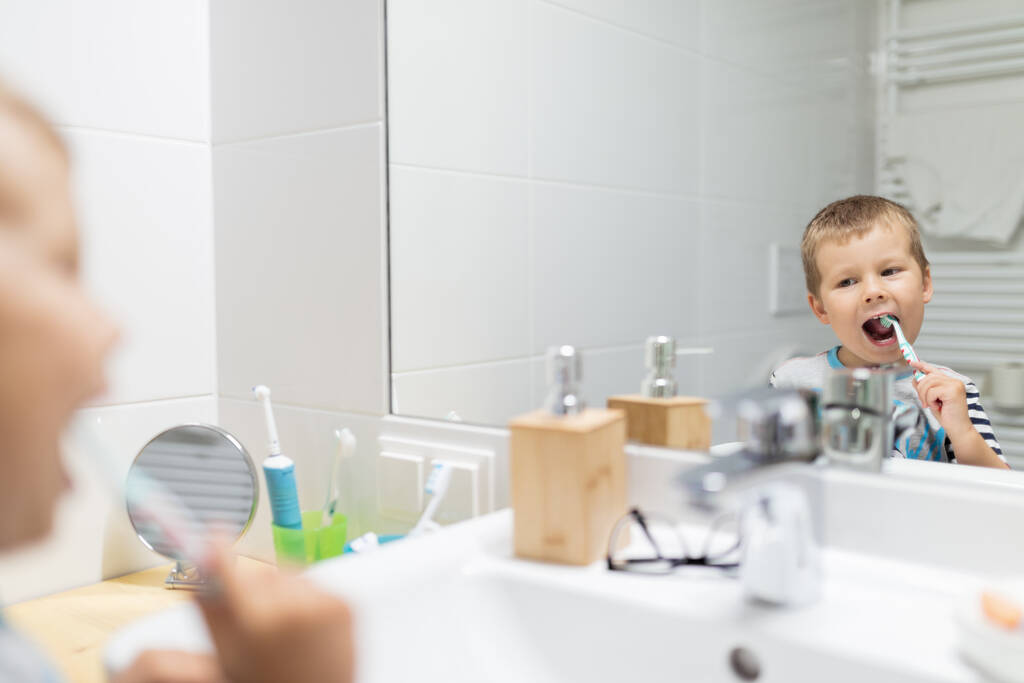 Очаровательный ребенок чистит зубы в ванной - Фото, изображение