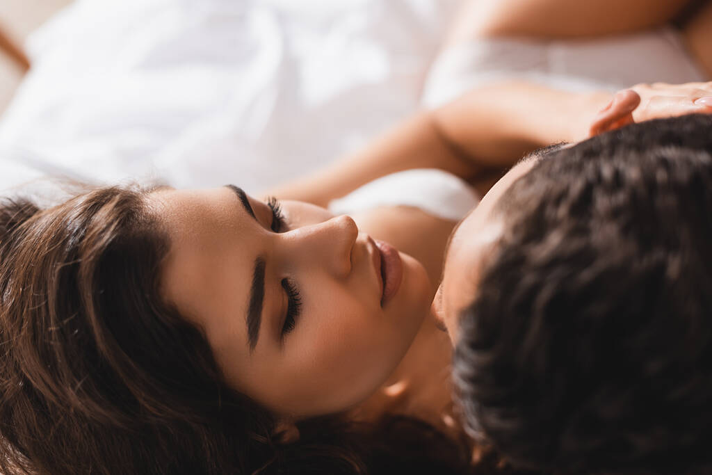 Yleisnäkymä seksikäs nainen koskettaa poikaystävä makuuhuoneessa  - Valokuva, kuva