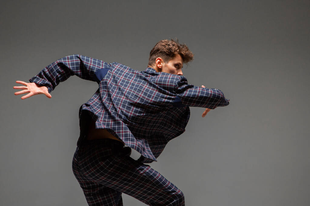 Stijlvolle jonge man danser in pak dansen moderne expressieve dans in de studio. Een poster van de dansschool. Danslessen - Foto, afbeelding