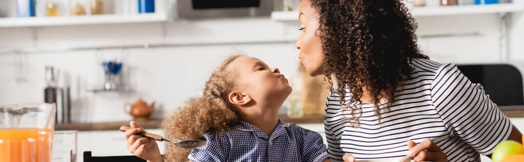 conceito horizontal de mãe e filha afro-americana mostrando rostos de pato uns aos outros durante o café da manhã  - Foto, Imagem