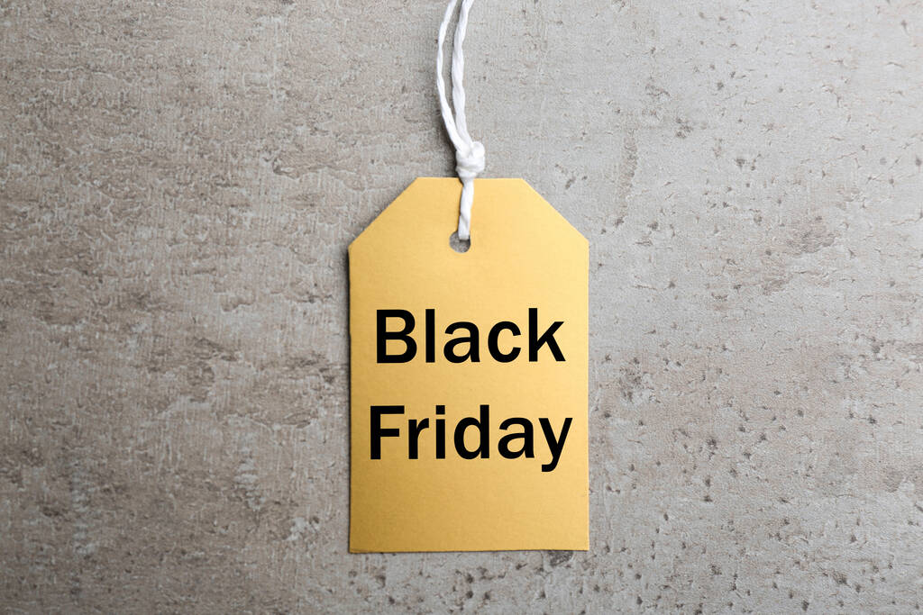 Blank golden tag on light grey stone background, top view. Black Friday concept - Photo, Image
