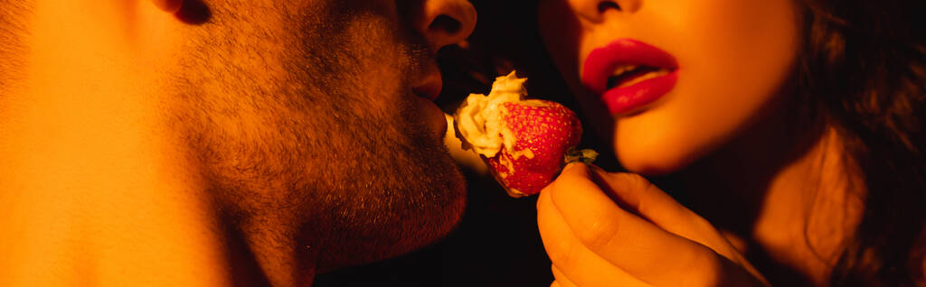 raccolto panoramico di donna con labbra rosse che alimentano l'uomo con fragola fresca  - Foto, immagini