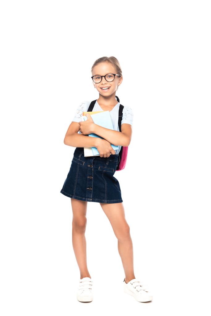 iskolás gyerek szemüvegben könyv, miközben áll, és nézi kamera elszigetelt fehér  - Fotó, kép