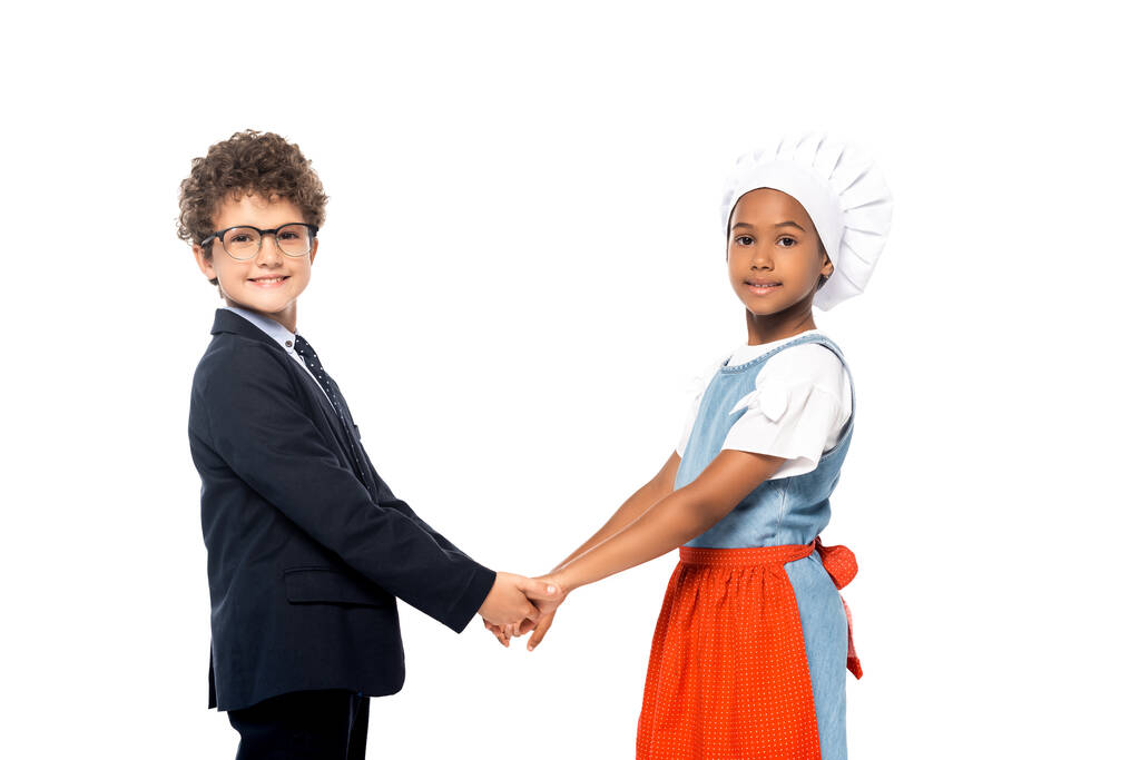 Африканский американец и мальчик в очках и костюме держась за руки изолированы на белом  - Фото, изображение