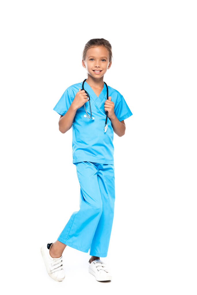 дитина в костюмі лікаря, який торкається стетоскопа, ізольована на білому
  - Фото, зображення